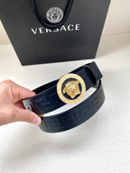 Navy Versace belt featuring gold round lion buckle on embossed strap