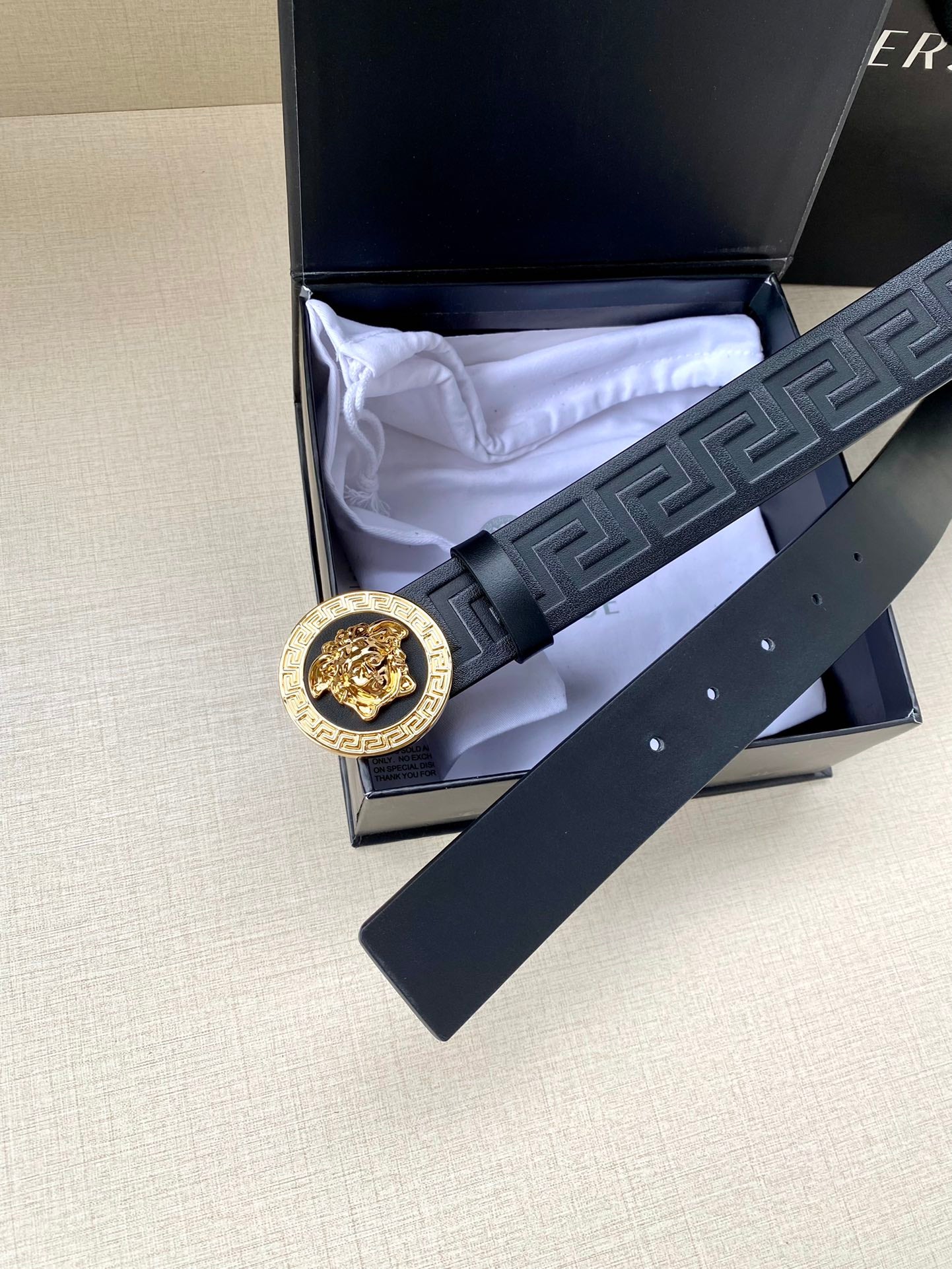 Navy Versace belt with Greca embossed strap, gold lion buckle, and box packaging