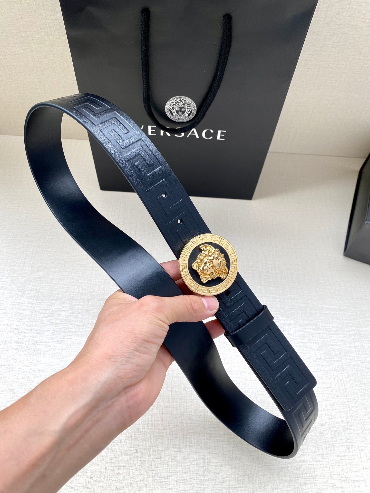 Navy Versace belt with Greca embossed strap and gold lion emblem buckle