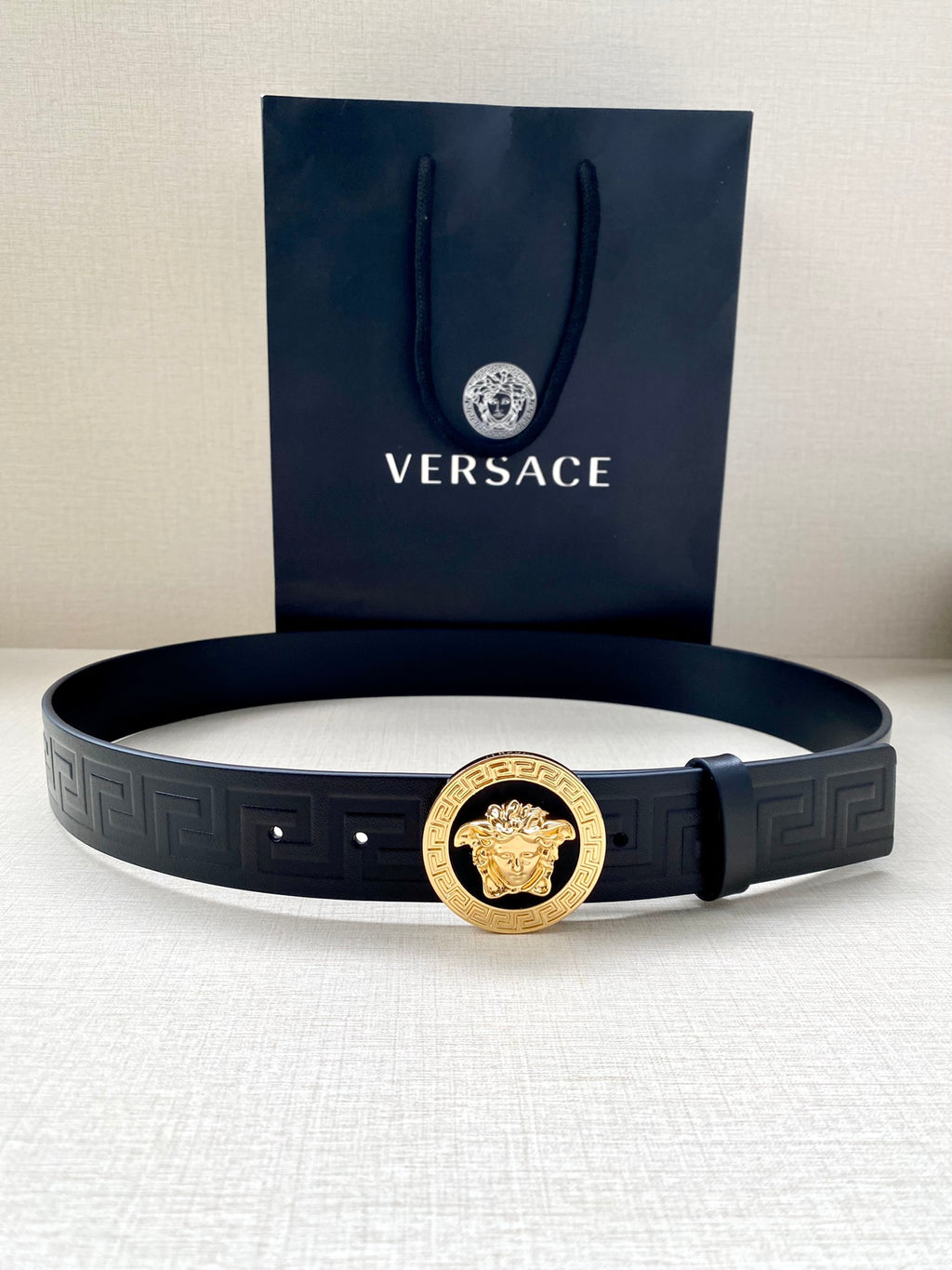 Versace navy belt with gold round lion buckle and embossed geometric strap