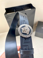 Navy Versace belt close-up showing round lion medallion and embossed logo pattern