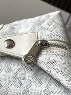 Goyard monogram clutch bag detail: snap button and D-ring on zip pull