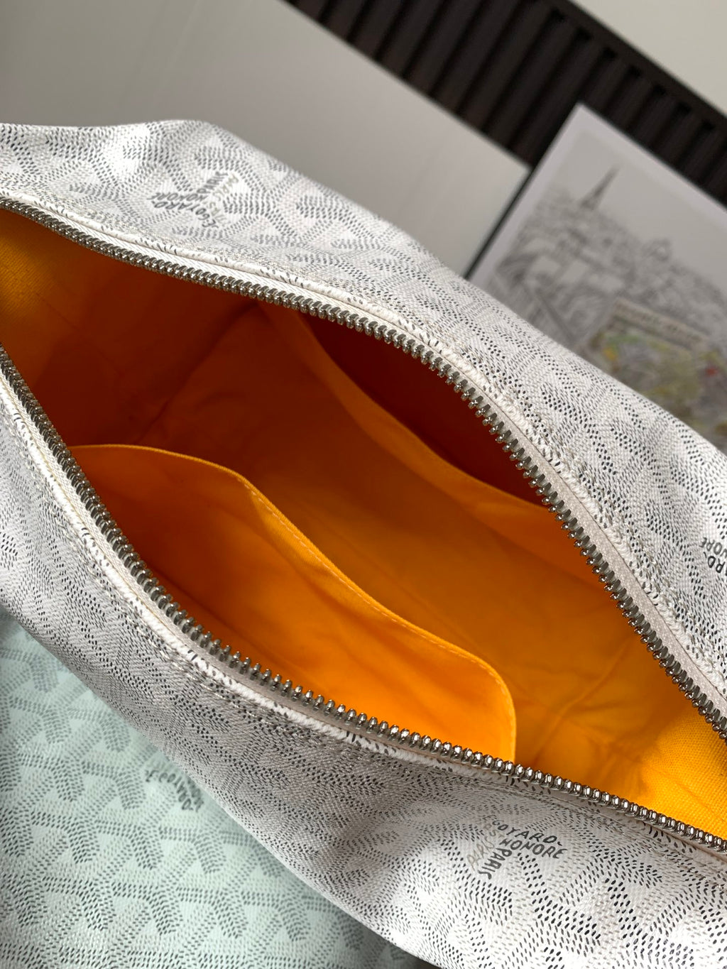 Goyard monogram clutch bag interior with orange lining and zippered top edge