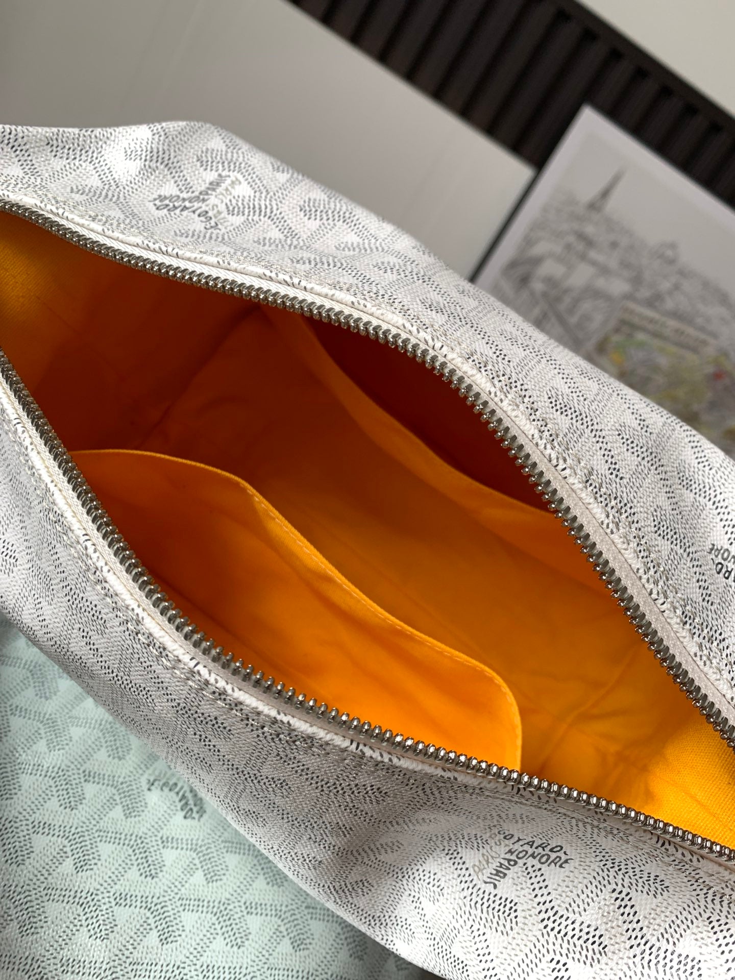 Goyard monogram clutch bag interior with orange lining and zippered top edge