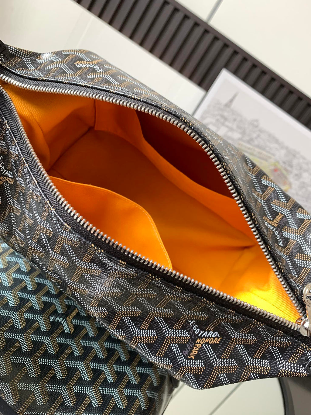 Pouch bag interior with orange lining and patterned canvas rim with zipper