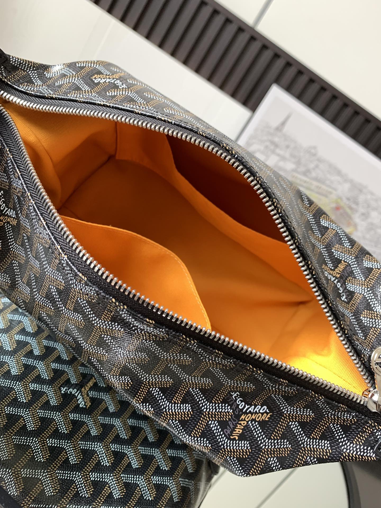 Pouch bag interior with orange lining and patterned canvas rim with zipper