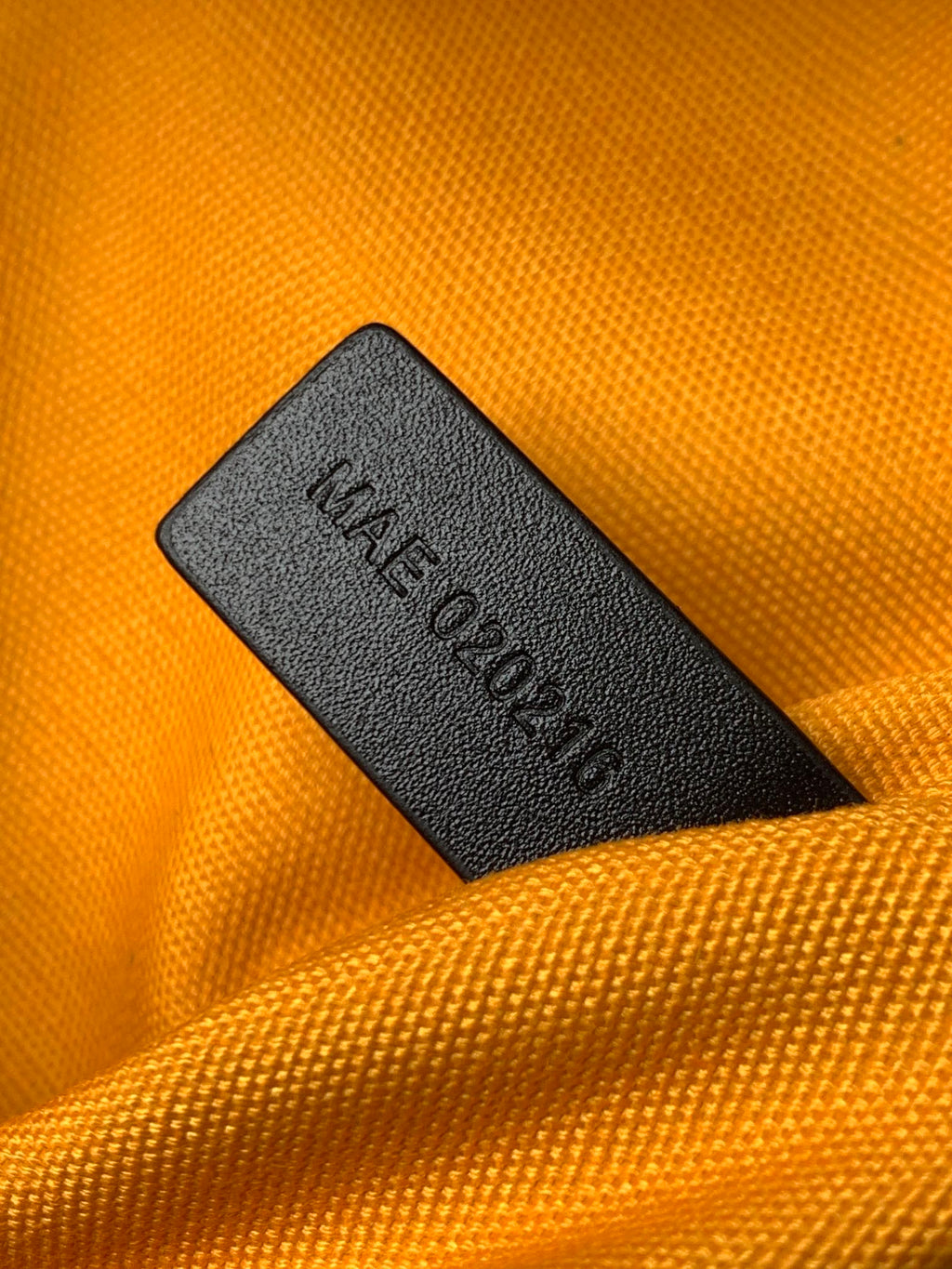 Interior fabric label reading 'Made in...' on orange bag lining