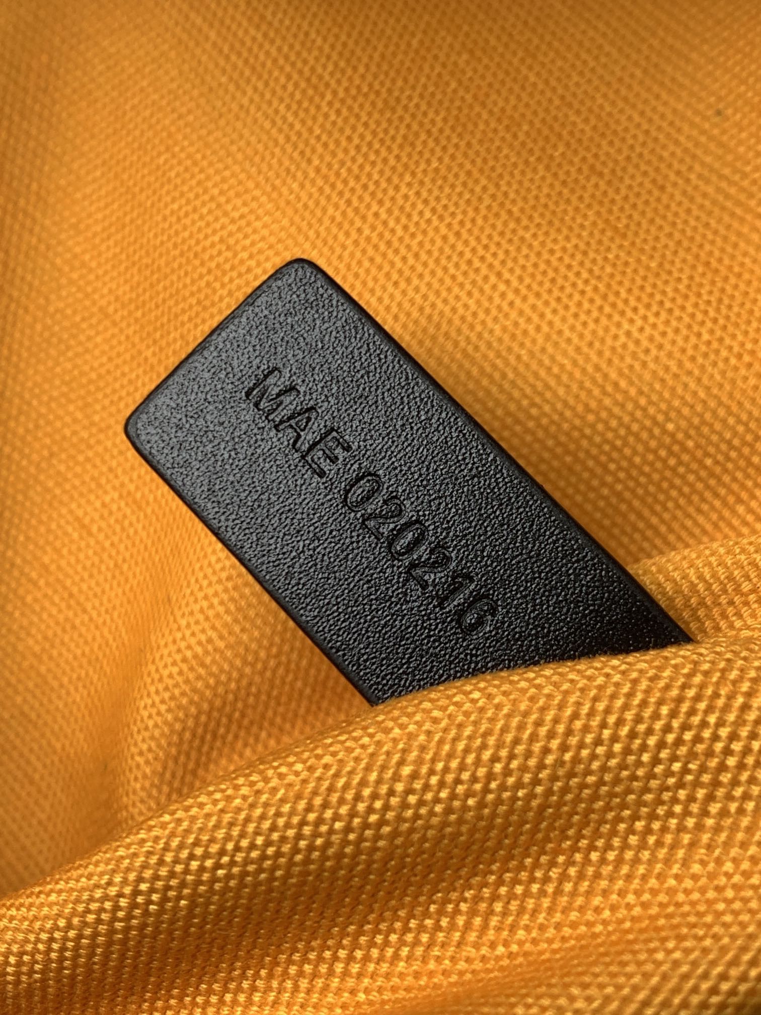 Interior fabric label reading 'Made in...' on orange bag lining