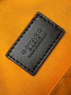 Orange fabric label patch on bag lining with black leather border