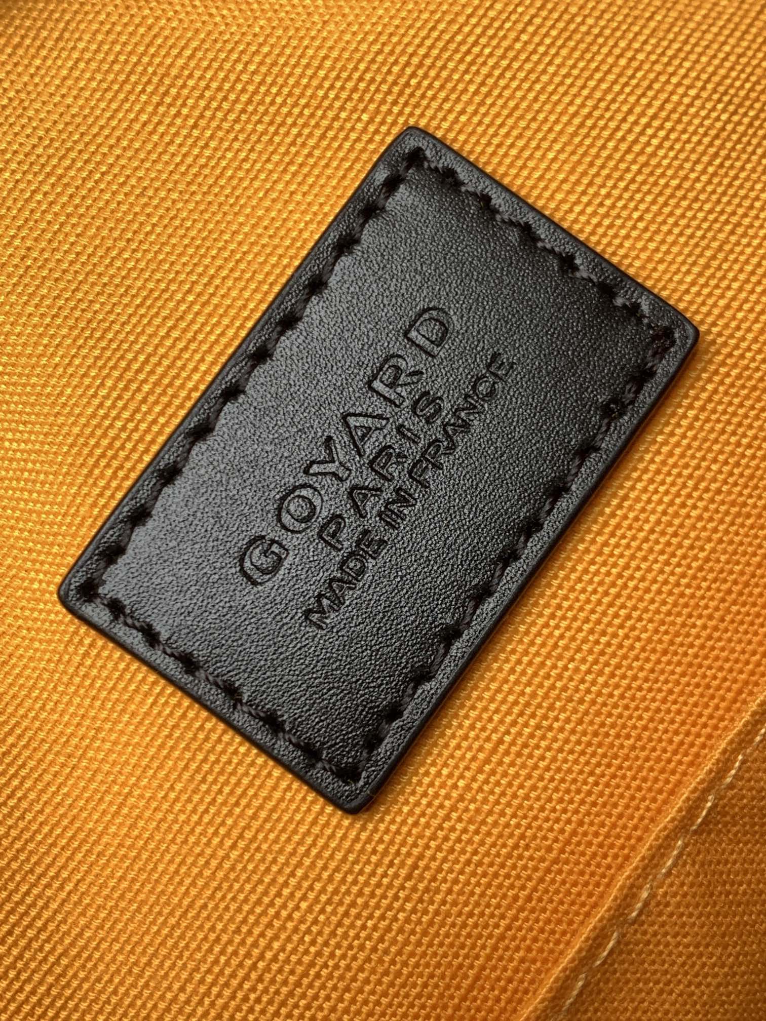 Orange fabric label patch on bag lining with black leather border