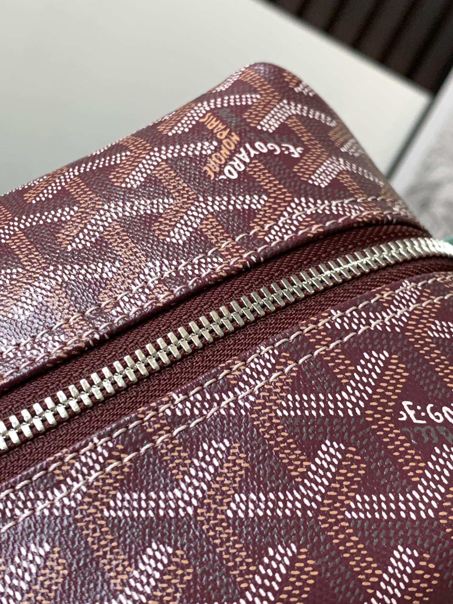 Goyard monogram bag close-up of top zipper and burgundy patterned canvas fabric