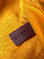 Goyard bag leather tag on orange fabric reading “MADE IN UAE 032124”