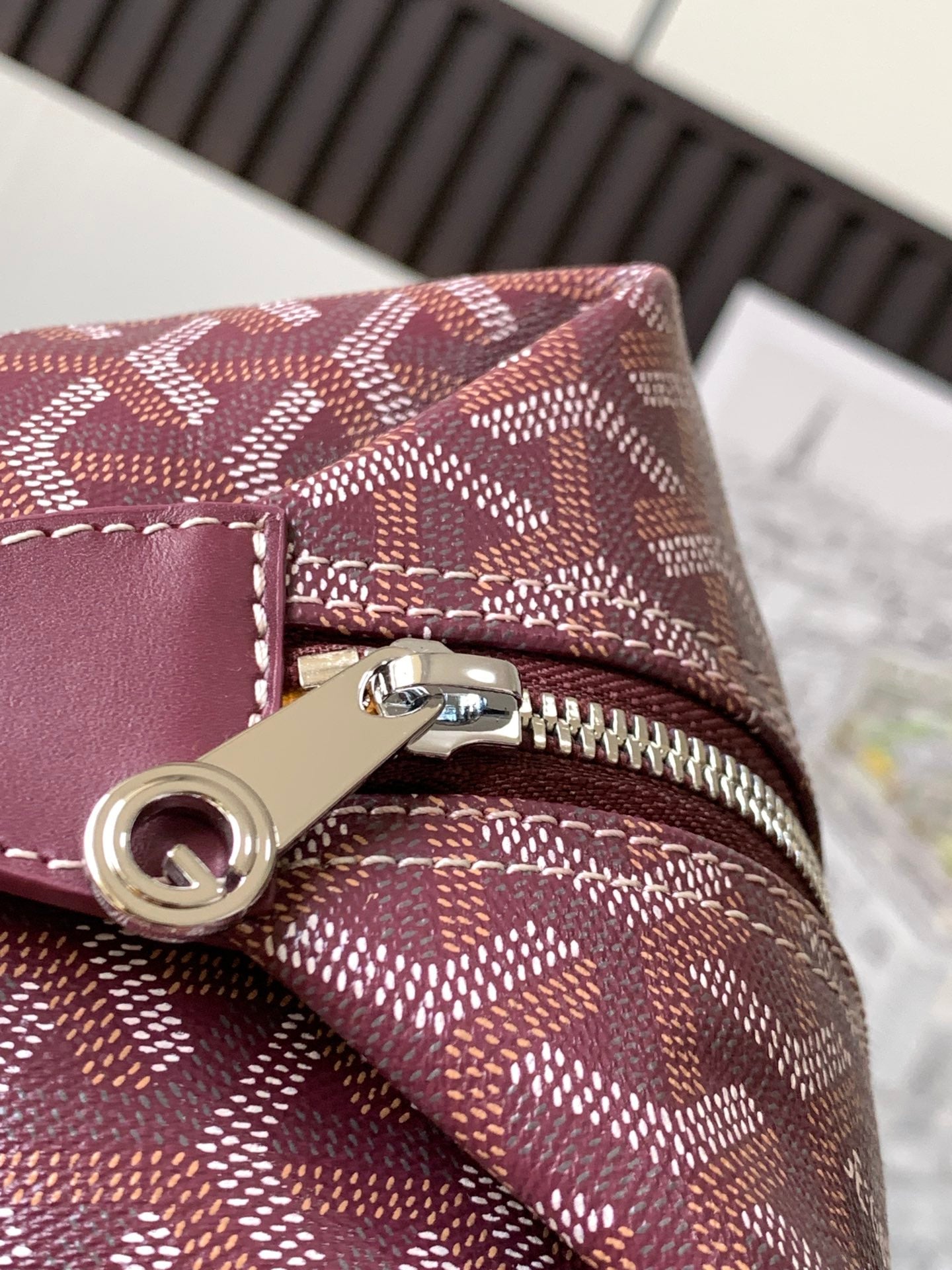 Goyard monogram bag zipper pull and metal hardware on burgundy patterned canvas