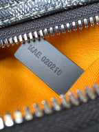 Orange lining leather tag stamped 'MADE 2022' under silver zipper teeth
