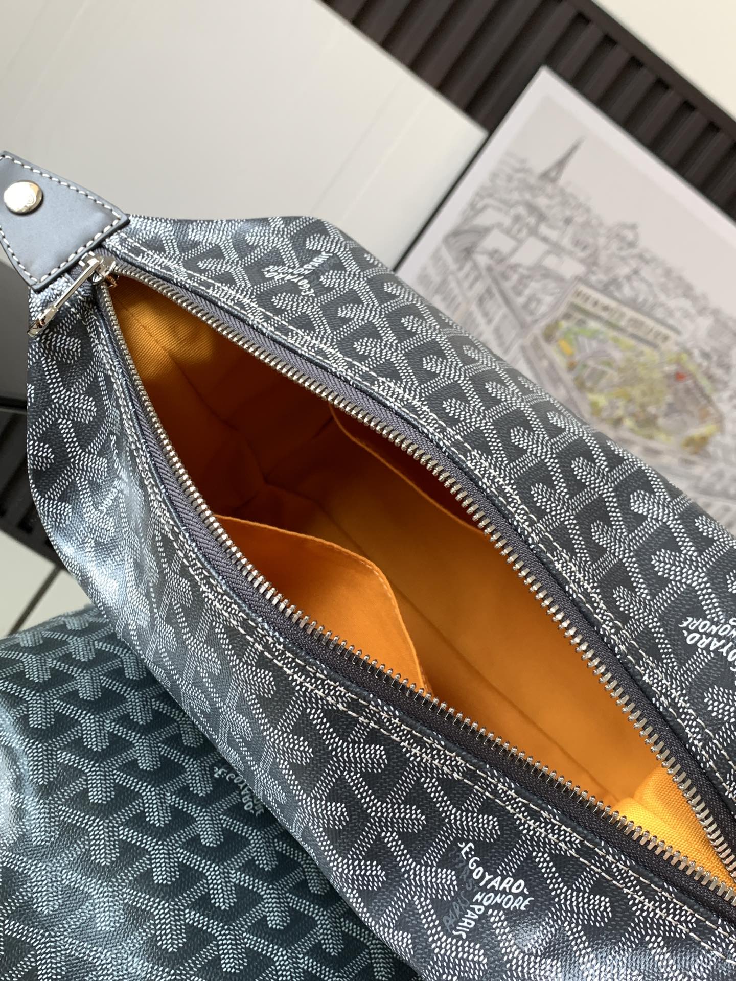 Dark gray patterned bag interior with orange lining and exposed top zipper