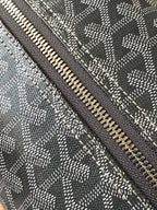 Closeup of dark gray zipper track with stitched edge along patterned fabric