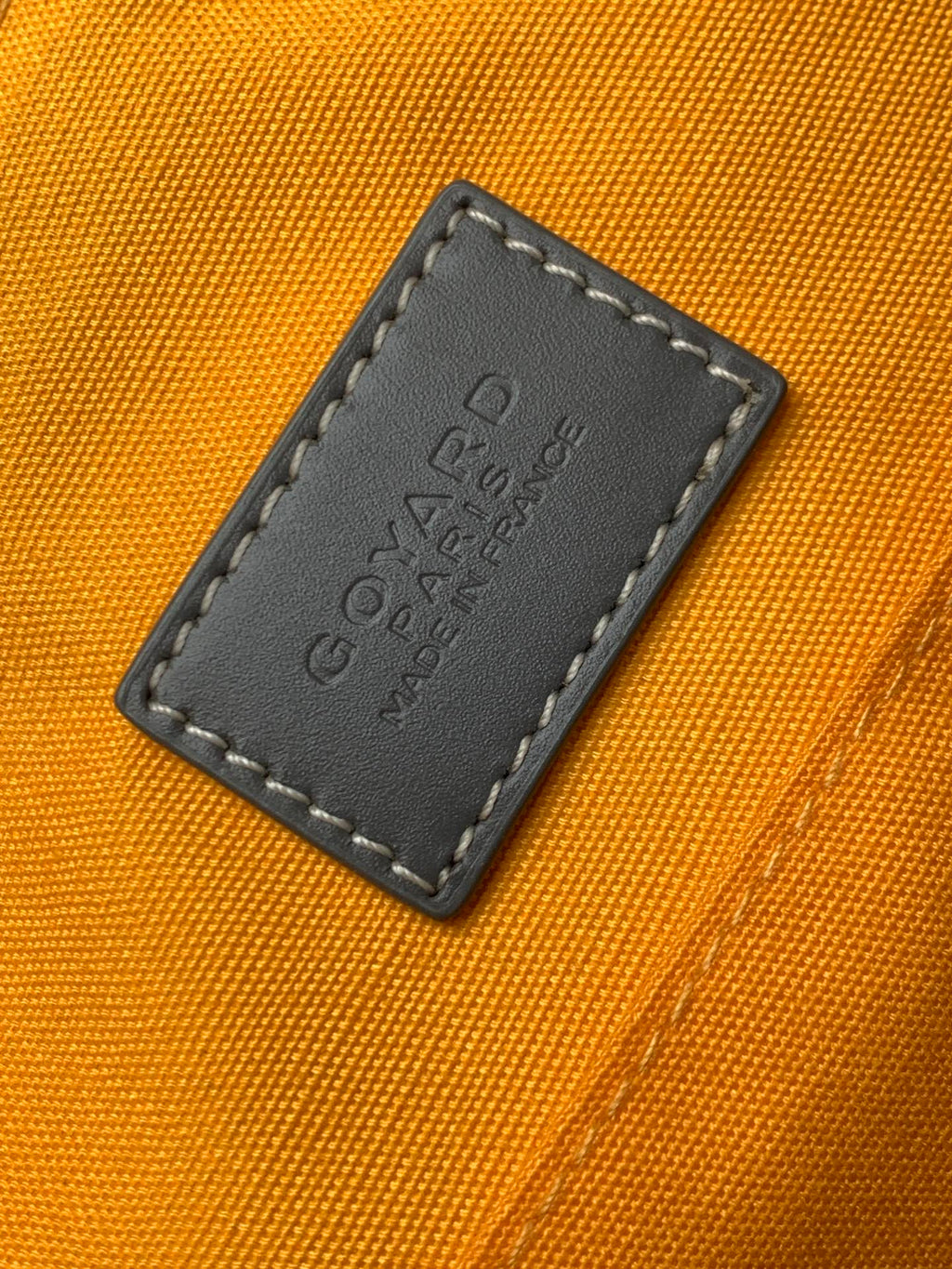 Orange interior lining with embossed leather label patch and dark stitched border