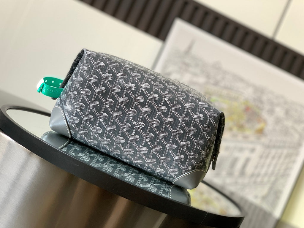 Dark gray patterned crossbody bag with front emblem and green strap loops