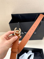 Tan leather belt with gold-tone CC logo buckle and visible strap holes