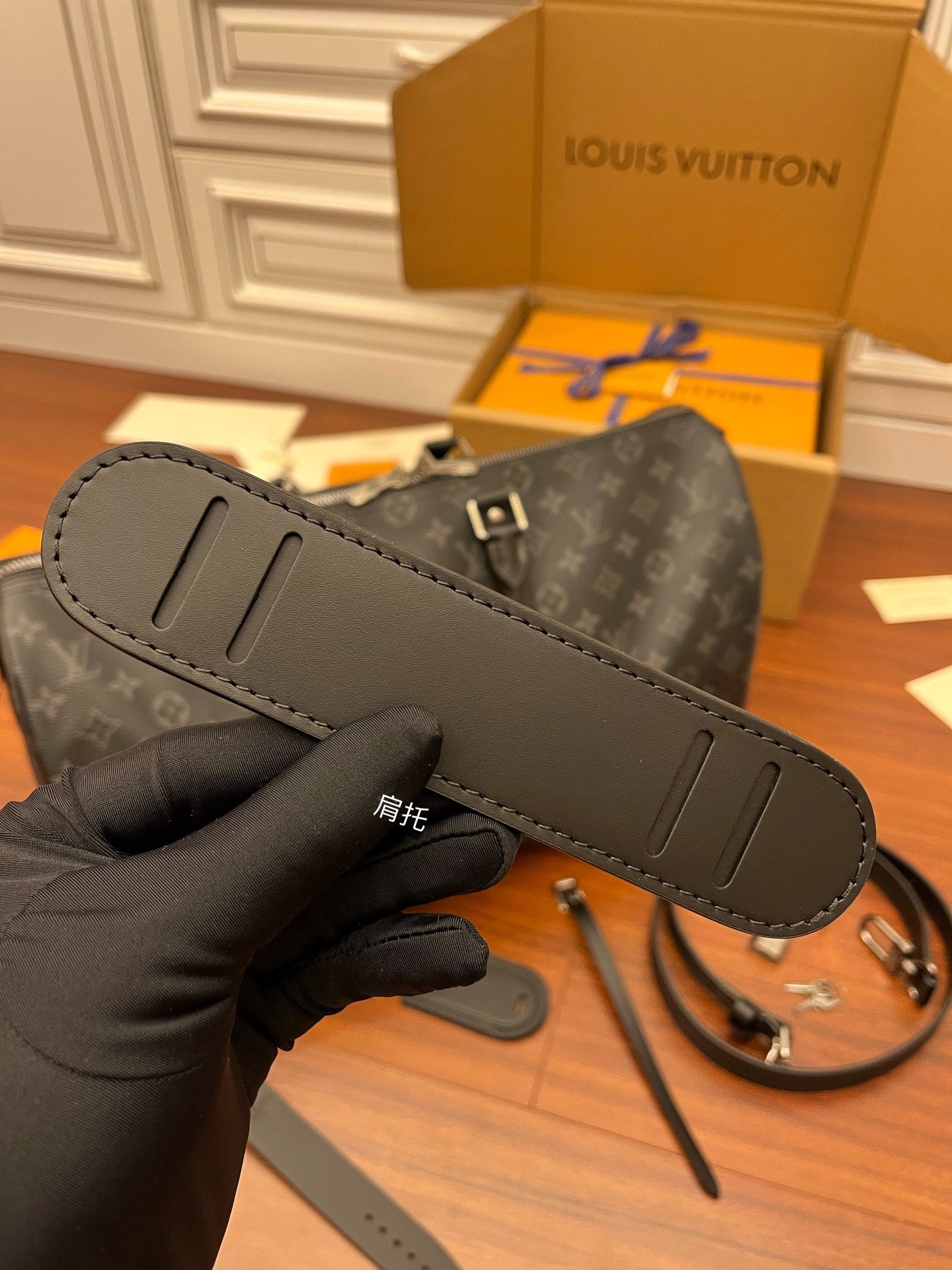 Louis Vuitton monogram duffle bag with gray leather strap in hand