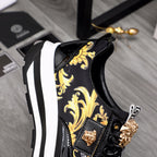 Versace black sneakers with gold baroque upper, lion emblem, and white stripe midsole