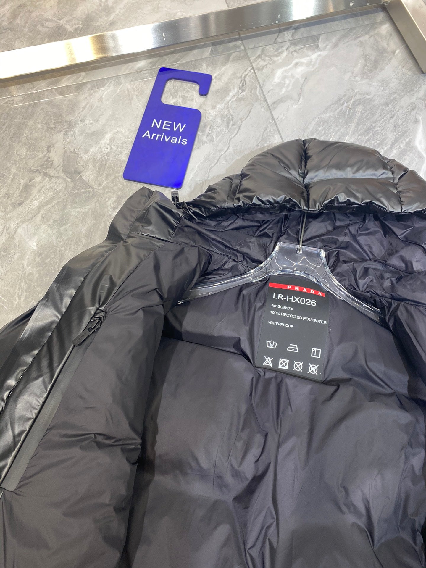 Black puffer jacket interior with brand label and care instructions