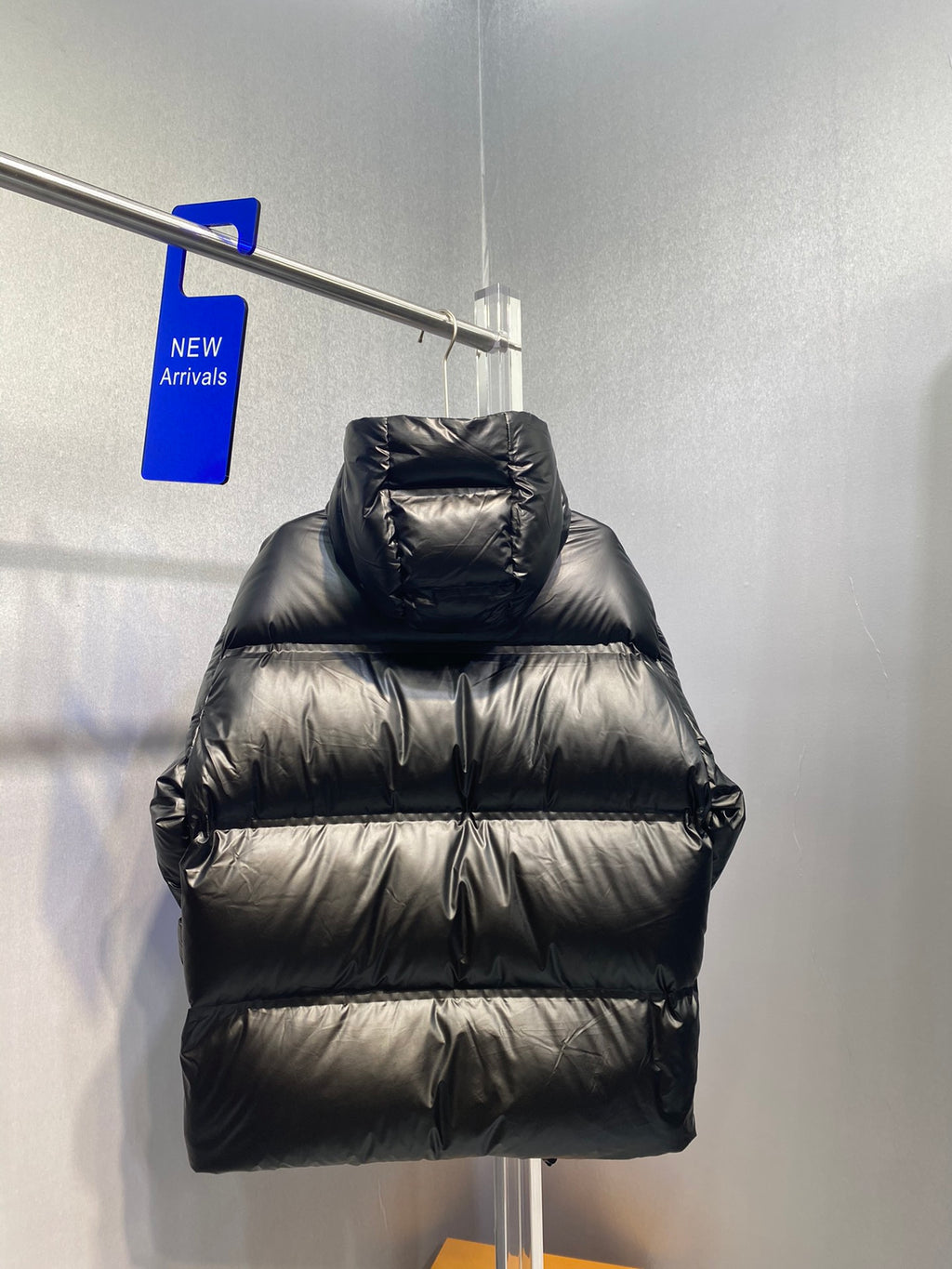 Black long puffer jacket with hood and zip front, quilted design and chest logo stripe