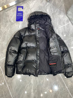 Black long puffer jacket with hood and front zip, quilted design and logo patch