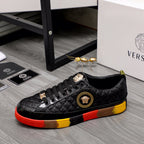 Black lace-up sneakers with gold crest logo on the side and red/yellow outsole
