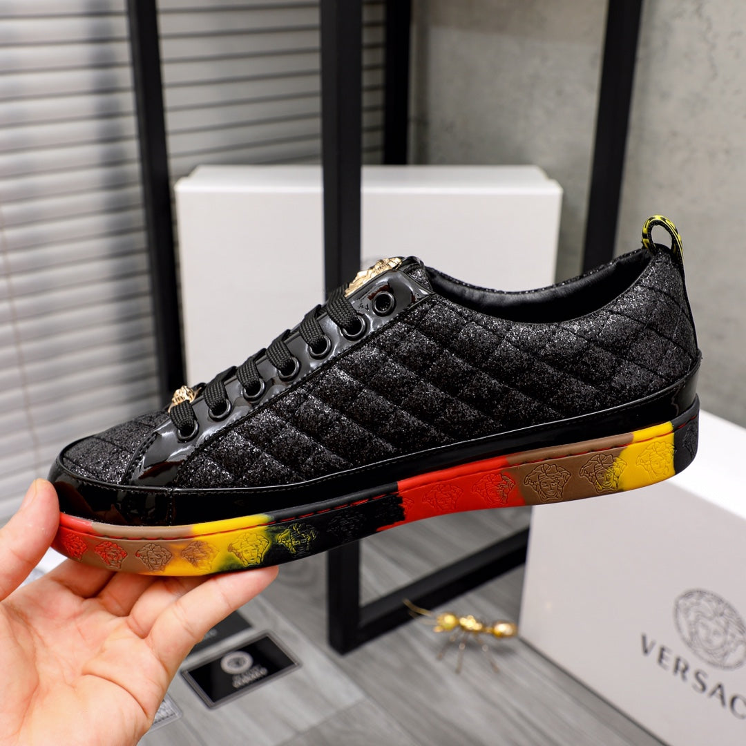 Black lace-up sneaker with gold accents and red/yellow contrast sole