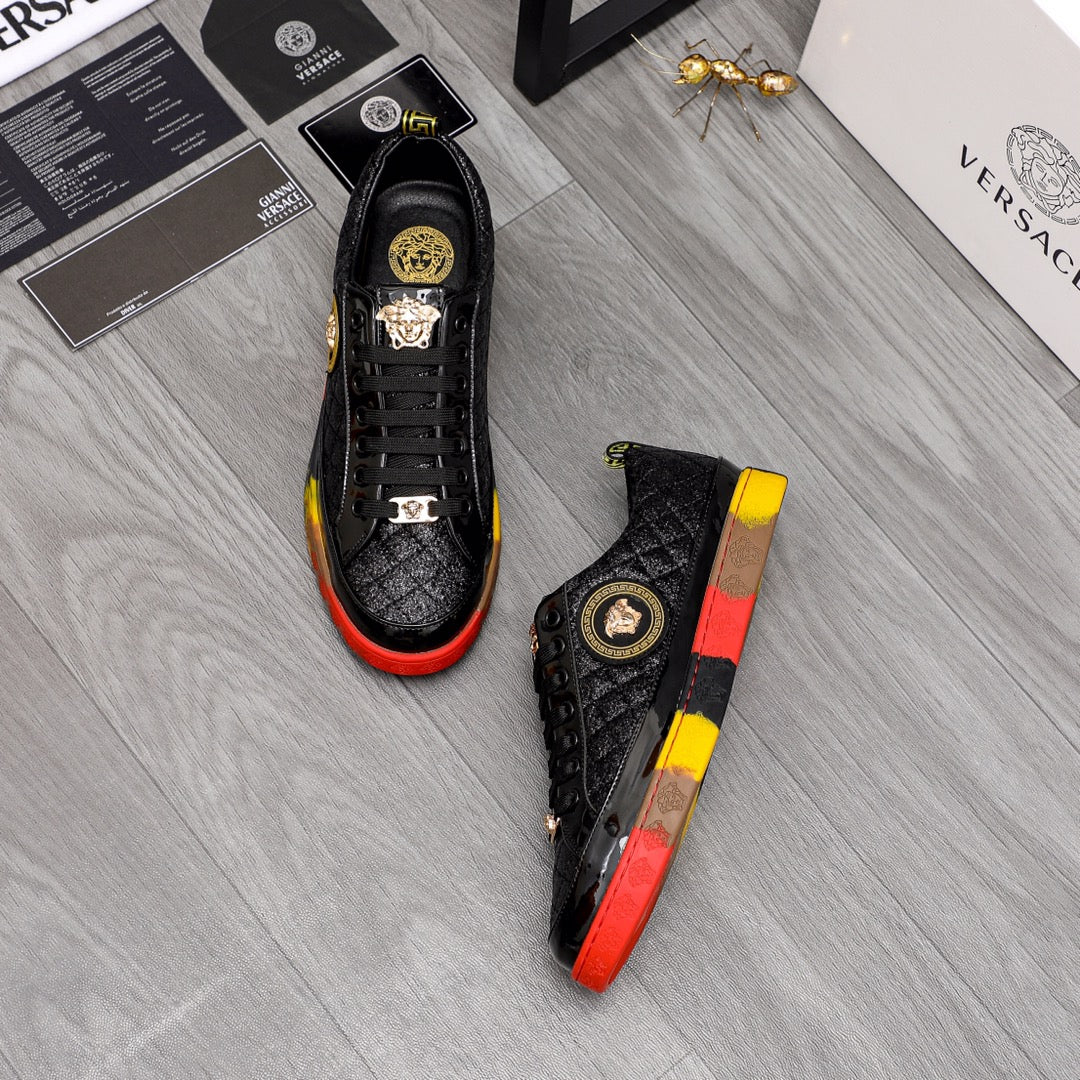 Pair of black lace-up sneakers with gold details and red/yellow contrast soles