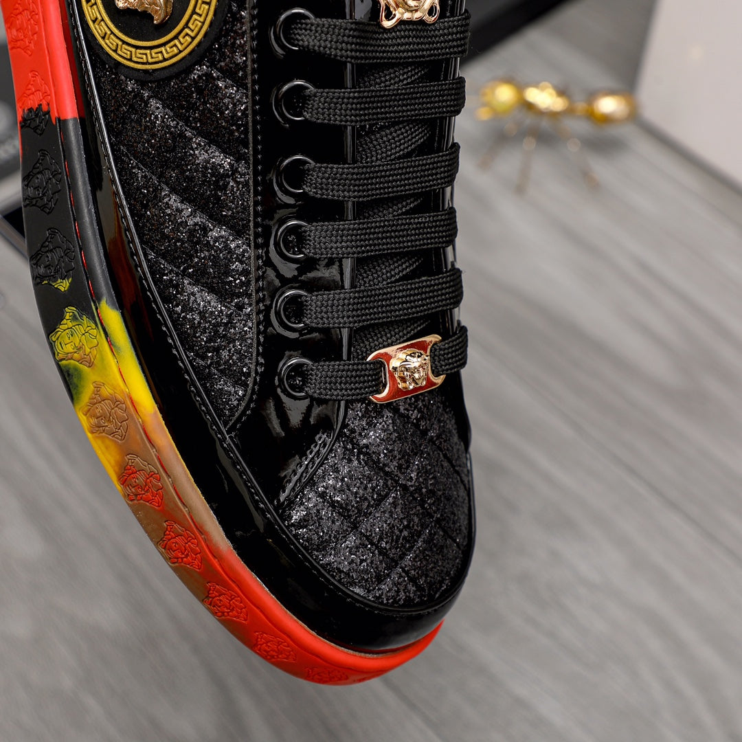 Close-up of black lace-up sneaker with gold buckle detail and red/yellow edge
