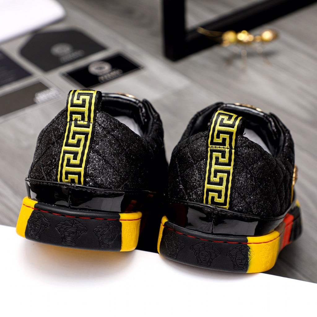 Black sneakers with yellow Greek key strap on the heel and red/yellow sole edge