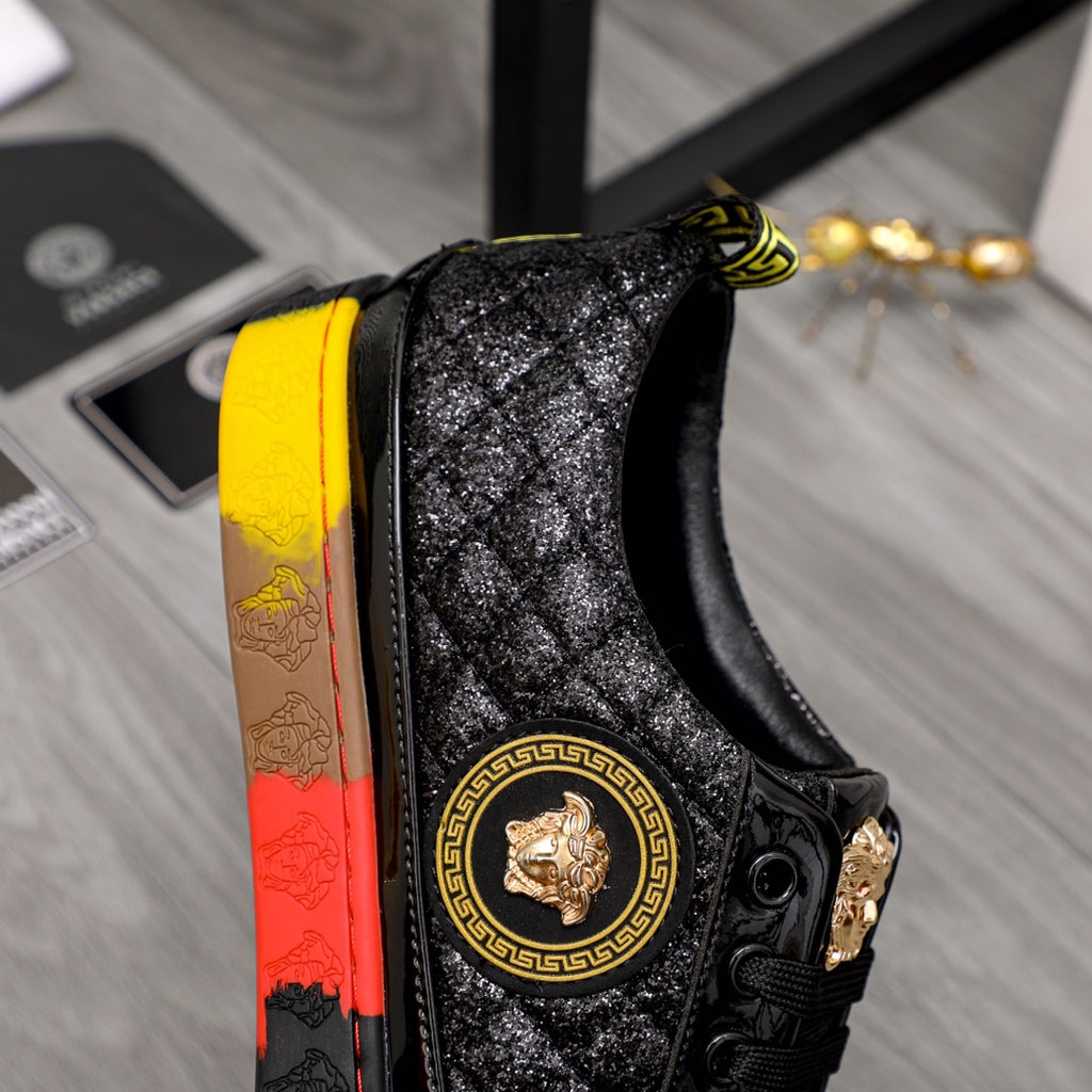 Close-up of black sneaker side with gold crest medallion and red/yellow outsole