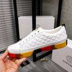 White quilted sneakers with white laces and gold accents on red-yellow rubber sole
