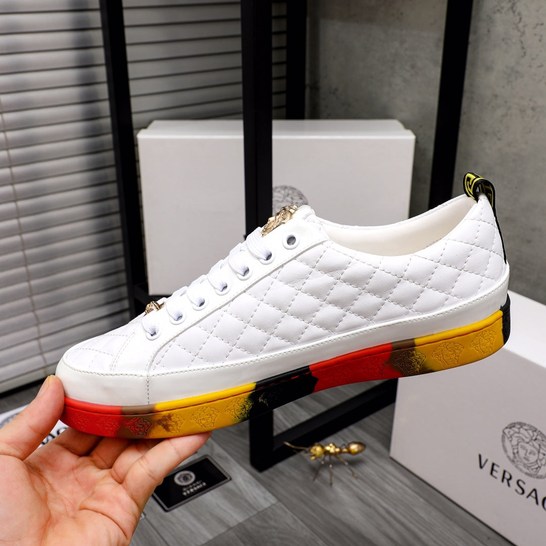 White quilted sneakers with white laces and gold accents on red-yellow rubber sole