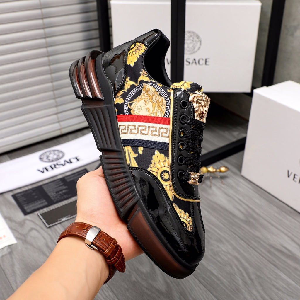 Versace luxury sneakers, black with gold medallion and red/white stripe panel, side view.