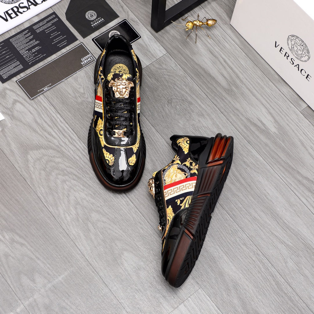 Versace luxury sneakers pair, black patent finish with gold crest details and side stripe.
