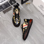 Versace luxury sneakers pair, black patent finish with gold crest details and side stripe.