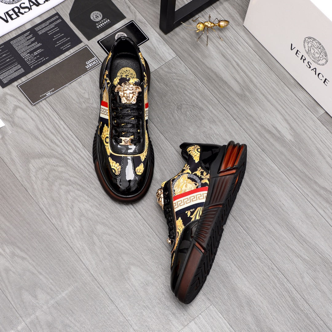 Versace luxury sneakers pair, black patent finish with gold crest details and side stripe.