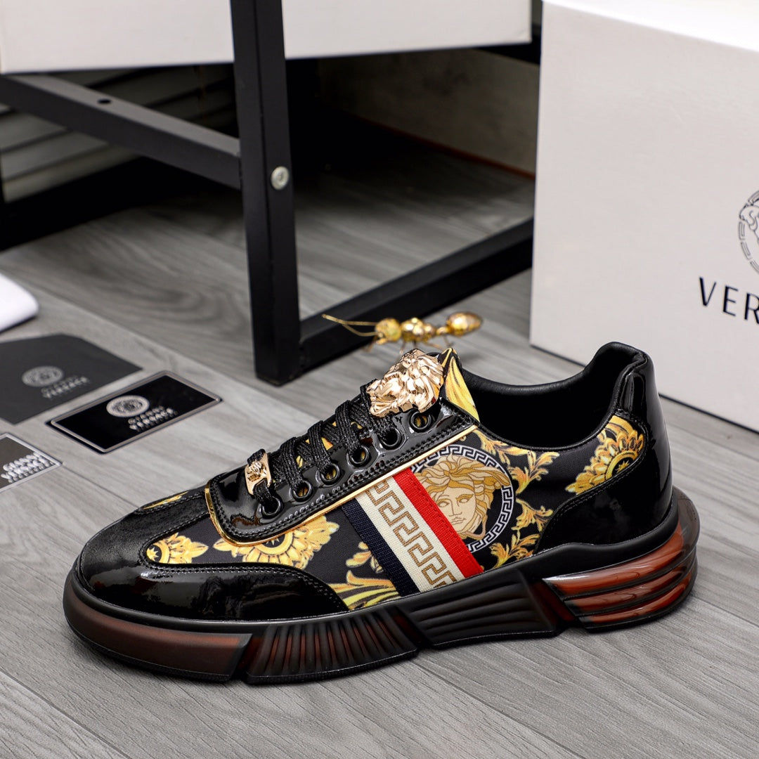 Versace luxury sneakers with gold baroque patch and red stripe detail on black uppers.