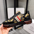 Versace luxury sneakers, black patent with gold design and red stripe center, front view.