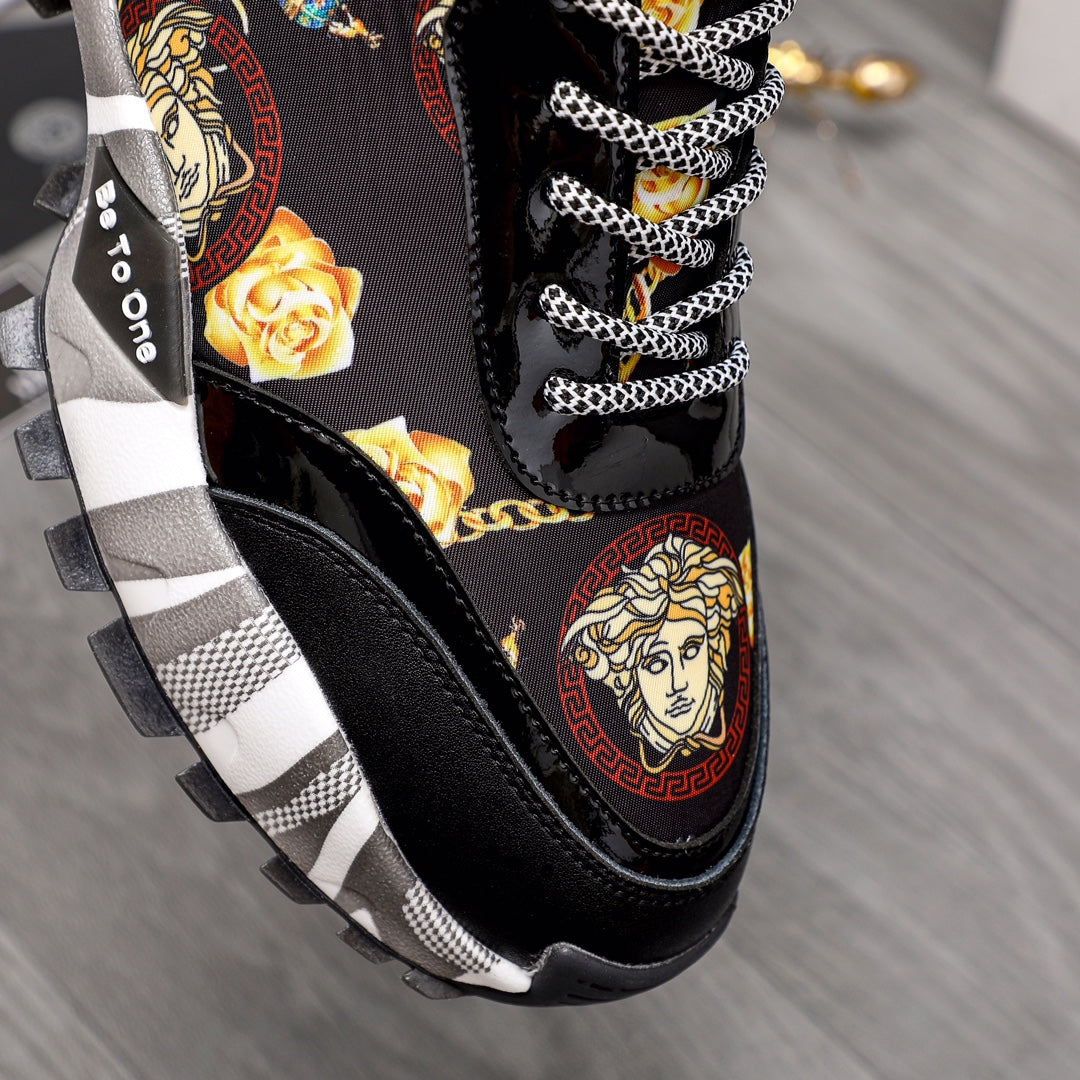 Close-up of black sneaker upper with baroque portrait graphic, gold roses, checker laces