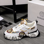White low-top sneakers with gold Medusa hardware, patterned side panel, chunky sole
