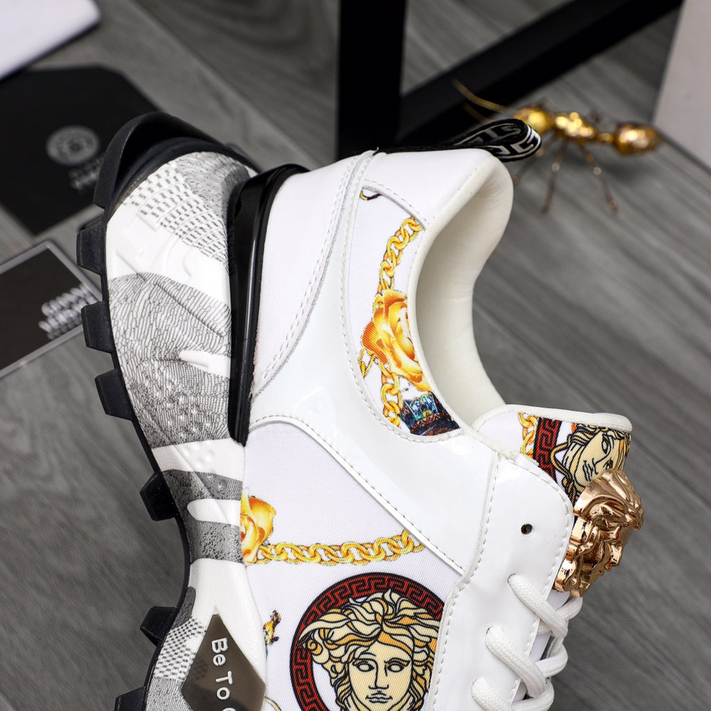 White sneaker side view with gold Medusa hardware, patterned panel, chunky sole