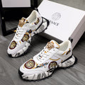 White sneakers with gold Medusa detail, patterned panels, and chunky black sole