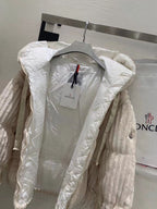 Cream hooded puffer jacket, front zipper visible, with logo patch on chest