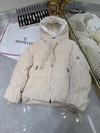 Cream long puffer jacket with hood, zipper front, and corded pull tabs