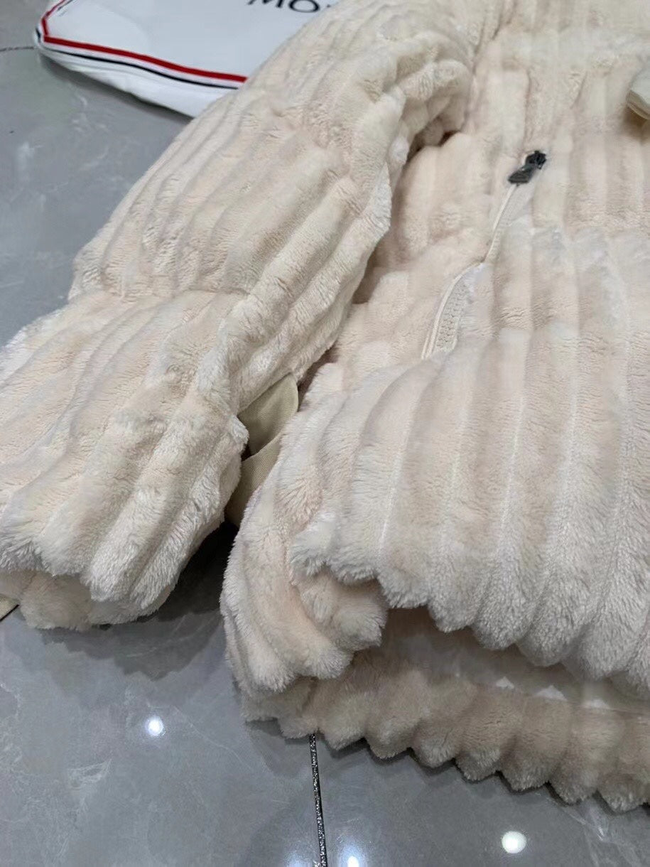 Close-up of cream puffer jacket with ribbed quilting and plush hood lining