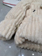 Close-up of cream puffer jacket with ribbed quilting and plush hood lining